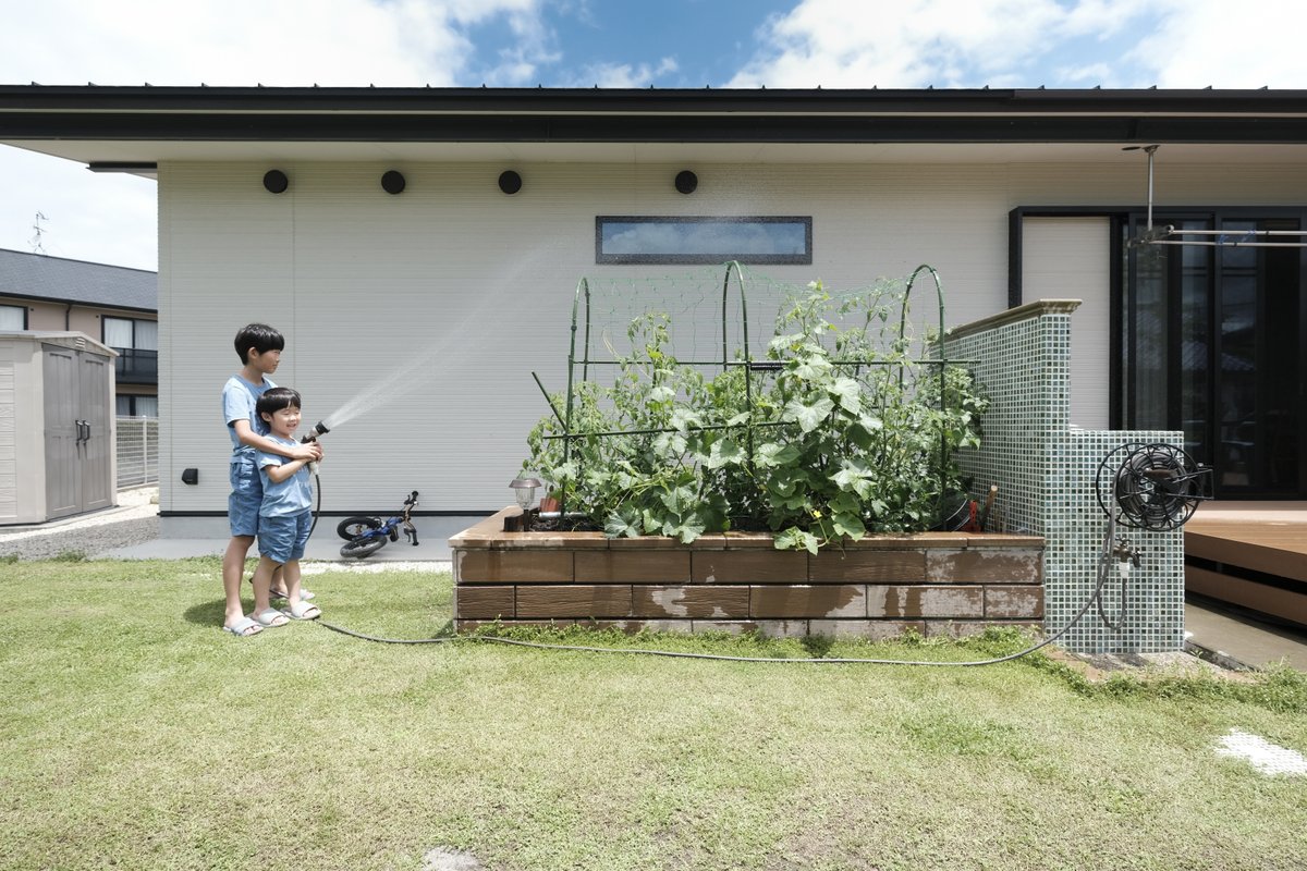 画像おしゃれな壁付けホースリールと水まき・水遊びを楽しむ夏休みの兄弟