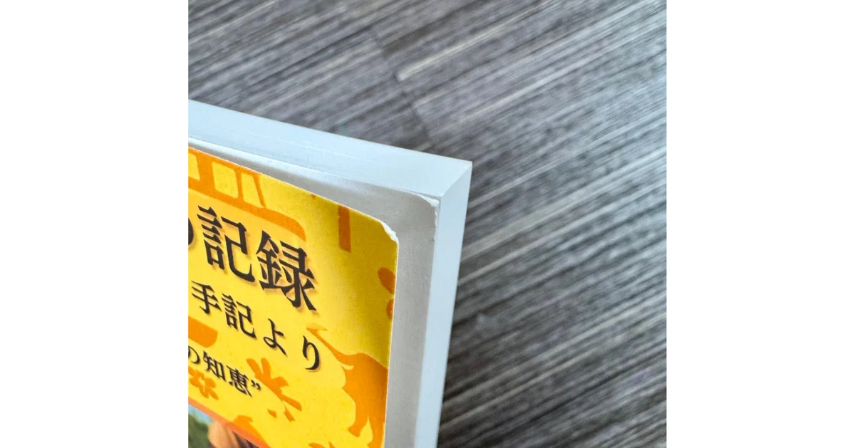 KDPペーパーバックの印刷本。配送時の梱包の影響で、表紙の角が潰れて折れ目がついている様子。