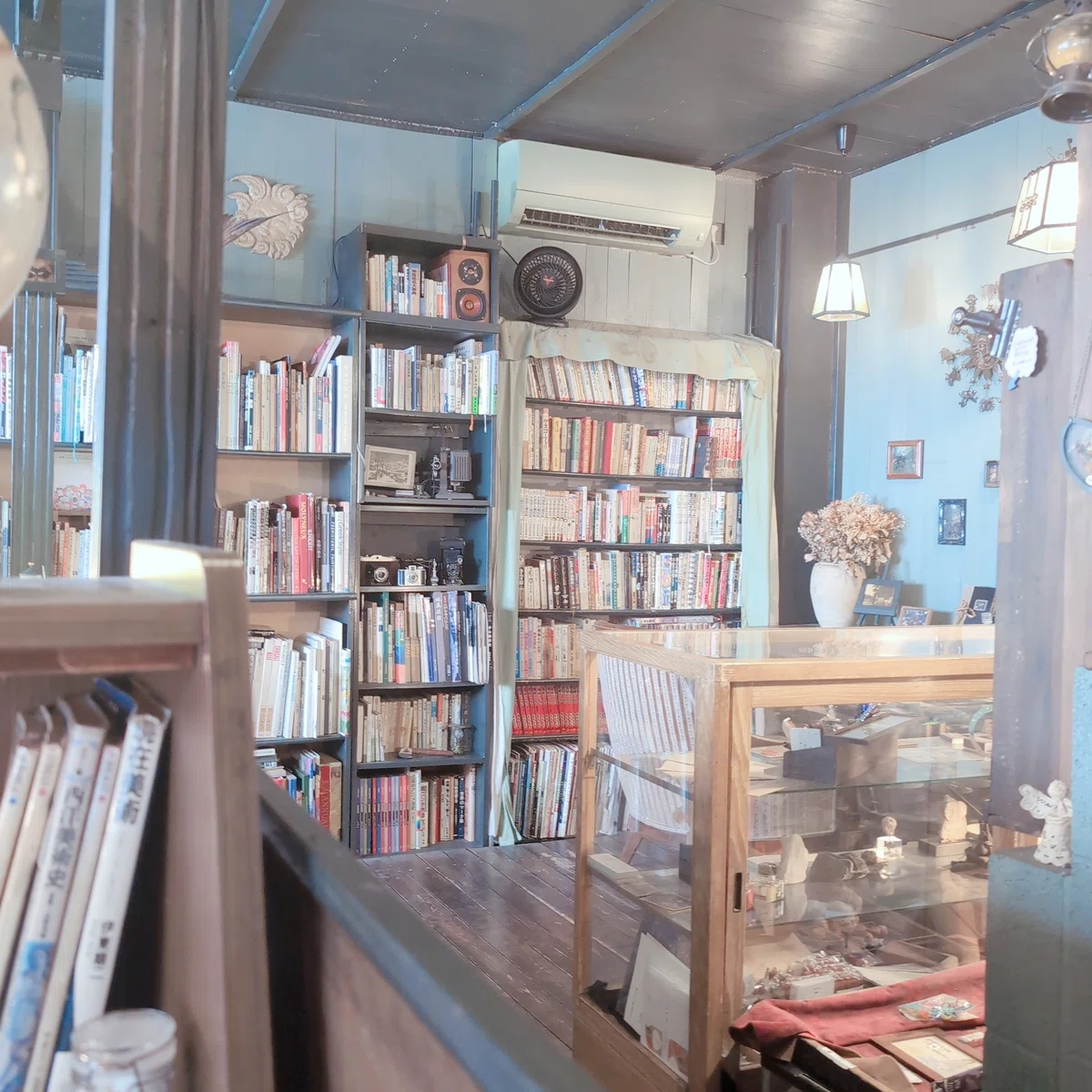 読書カフェの店内。アンティークふうな装飾品が並び、本棚にたくさんの本が並んでいる
