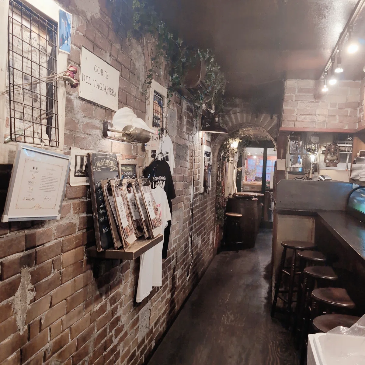 レストランの店内。レンガ風の壁に雑貨が飾られ、その向かいにカウンター席がある。