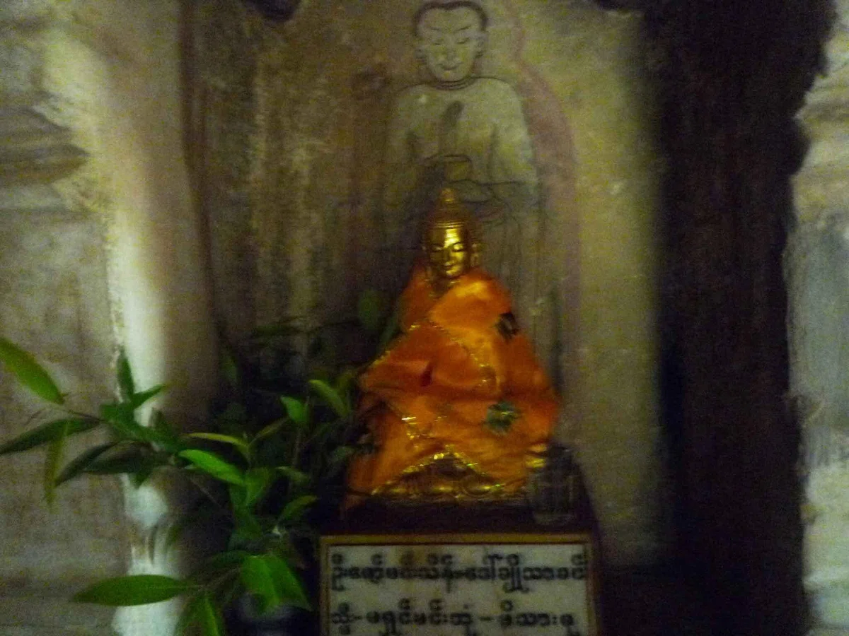 壁画の痕が残る小さな祠と金色の小像