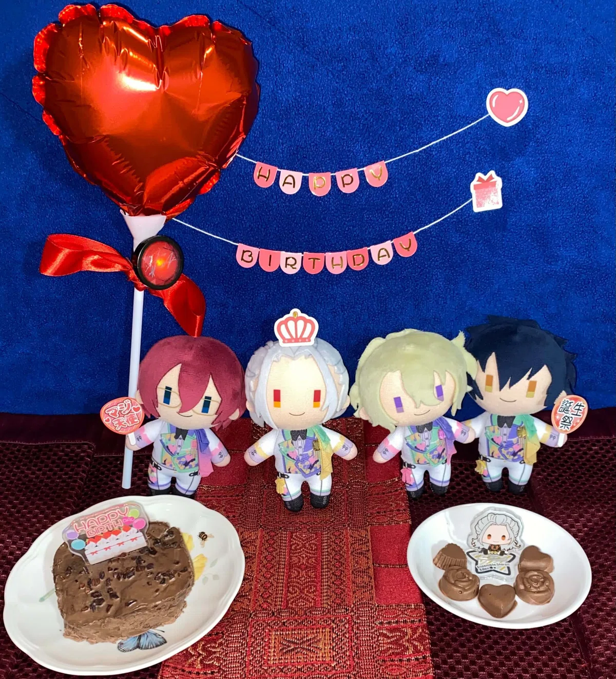 「Eden」のメンバーのコスチュームマスコット(8th Anniversary)が、乱凪砂くんのお誕生日をお祝いするように並んでいます。ぬいぐるみのそばには、手作りのチョコレートとミニバースデーケーキ、誕生日グッズを添えました。