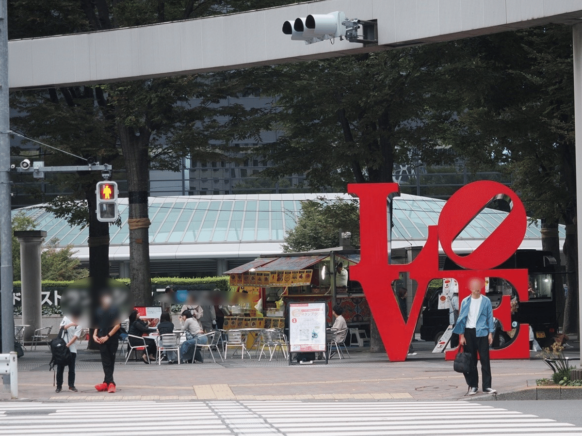 5号街路で開催された「FUN MORE TIME SHINJUKU 2025」の様子。写真右に「LOVE(赤)」のオブジェがあり、写真の真ん中ではスタンプラリーやキッチンカーの様子が写っている。