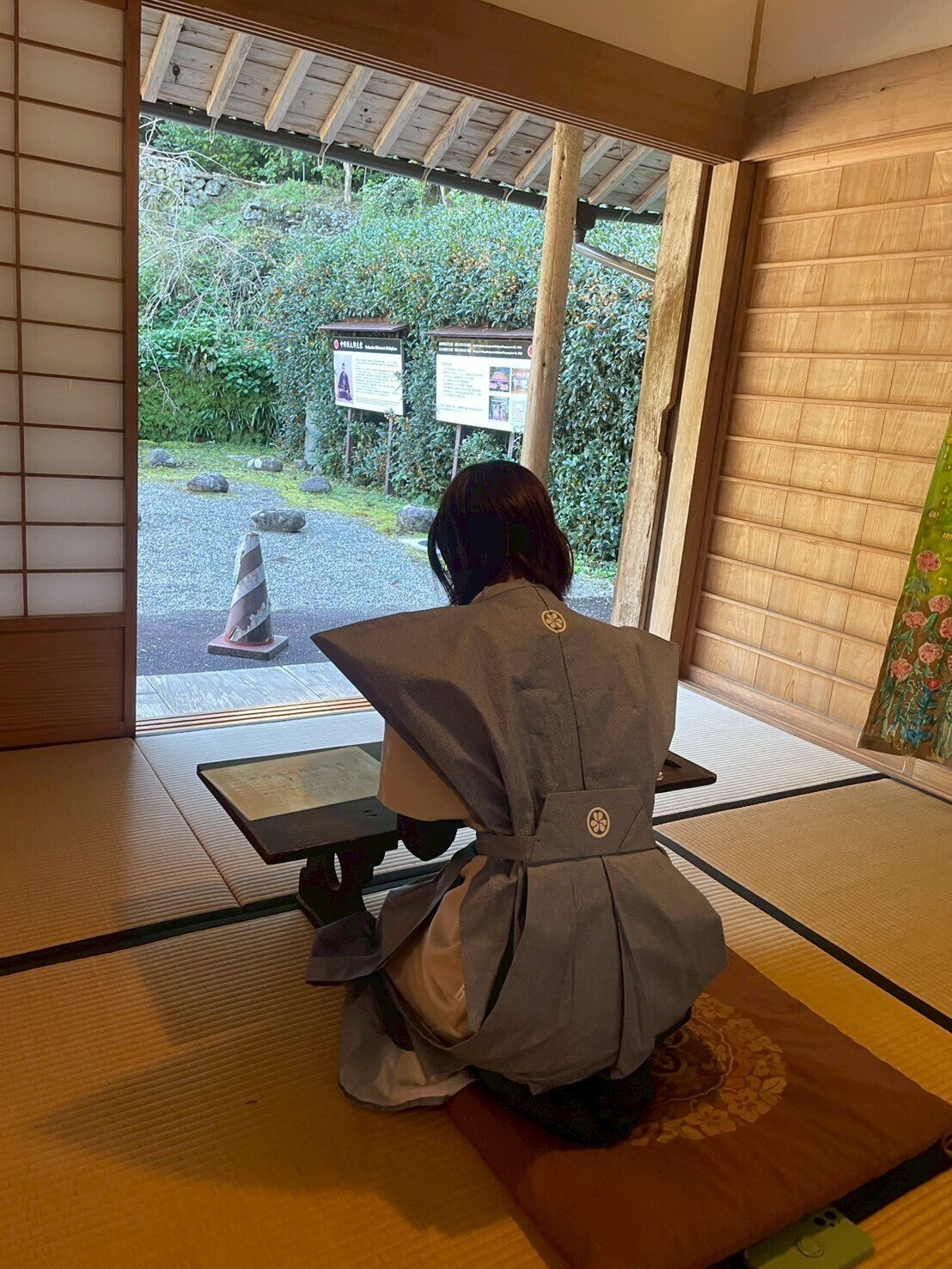 中岡慎太郎生家の屋内。中岡慎太郎の裃を着た人が、文机に座っている後ろ姿で写っている。