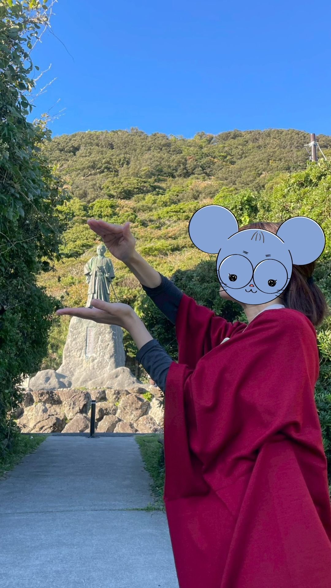 遠近法を使って、中岡慎太郎像を手乗りにしている風の写真。頭を撫でている風。