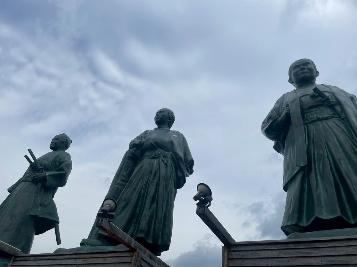 高知駅前の三志士像(武市半平太・坂本龍馬・中岡慎太郎)曇りの写真。