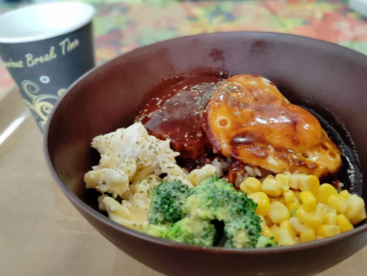 【写真 8ぶんの1】トレーに乗った茶色い器のロコモコ丼と紙コップのコーヒーの写真 見出し画像と同じもの