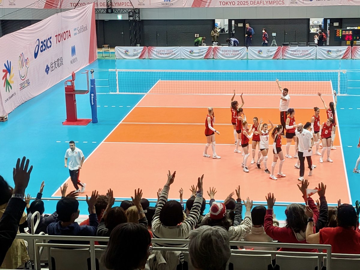 てのひらをひらひらさせて選手に拍手をおくる観客たち。観客席でみな両手をあげている