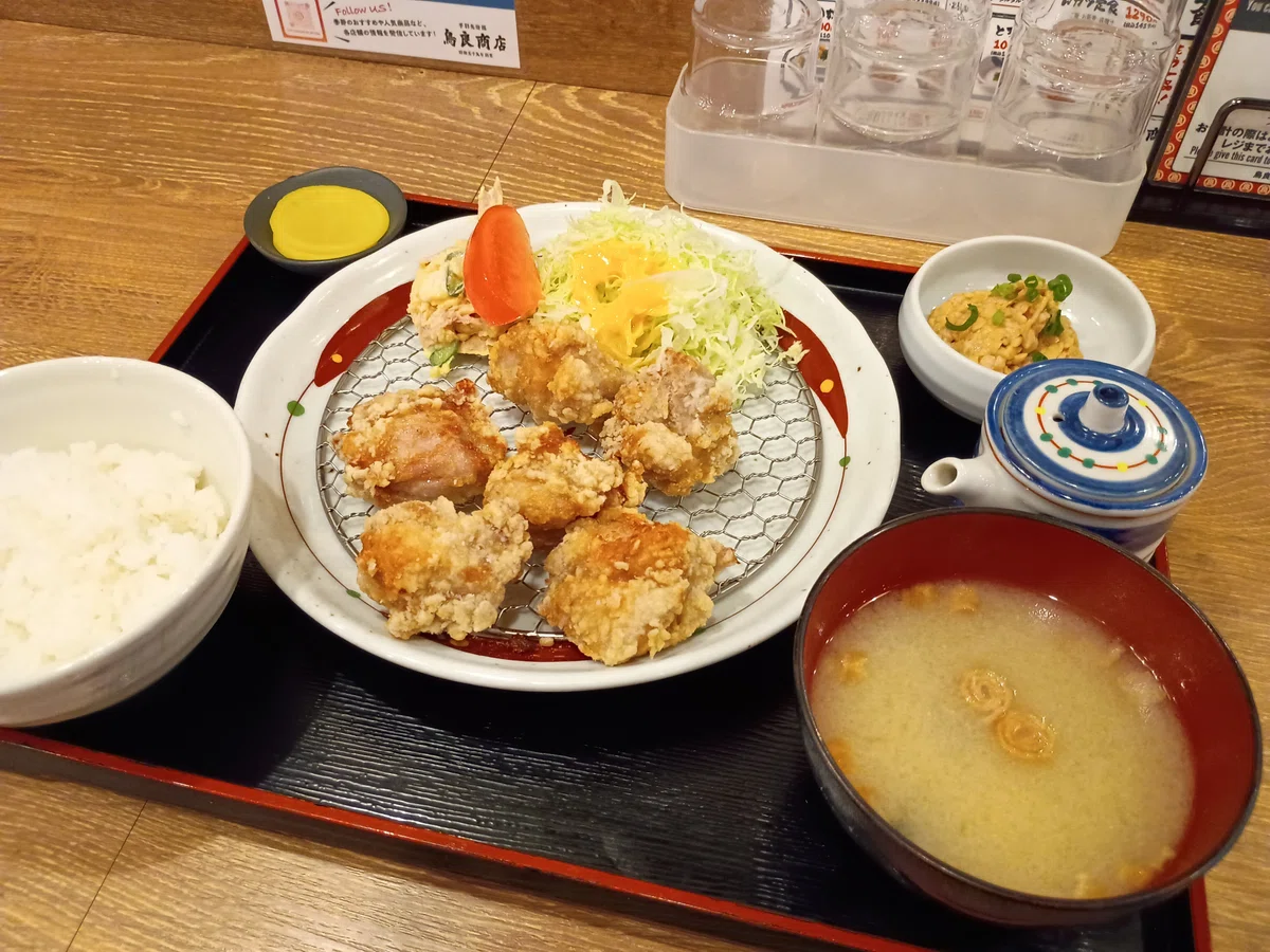 秘伝塩からあげ定食。ワイヤーラックに盛られた唐揚げ6個、千切りキャベツとトマト、白飯、味噌汁、ポテサラ、たくあんがセットになった定食