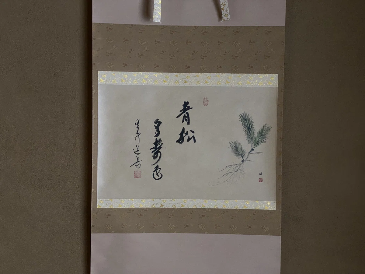 茶席の床の間に掛けられた禅語「青松多寿色(せいしょうじゅしょくおおし)」。東大寺別当筆の力強い墨跡。