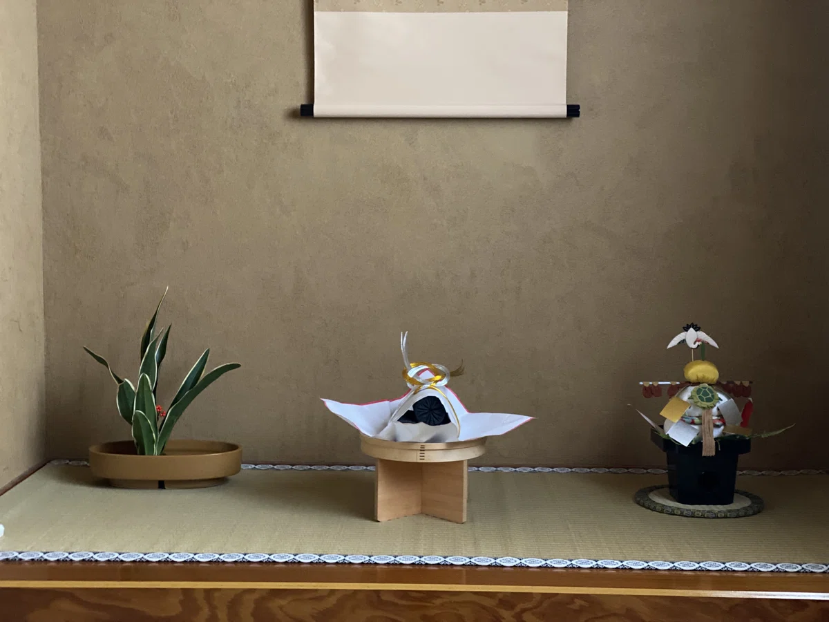 初釜の床の間飾り。奉書紙で包まれた炭飾り、蓬莱山(鏡餅)、万年青が生けられた新春の室礼。