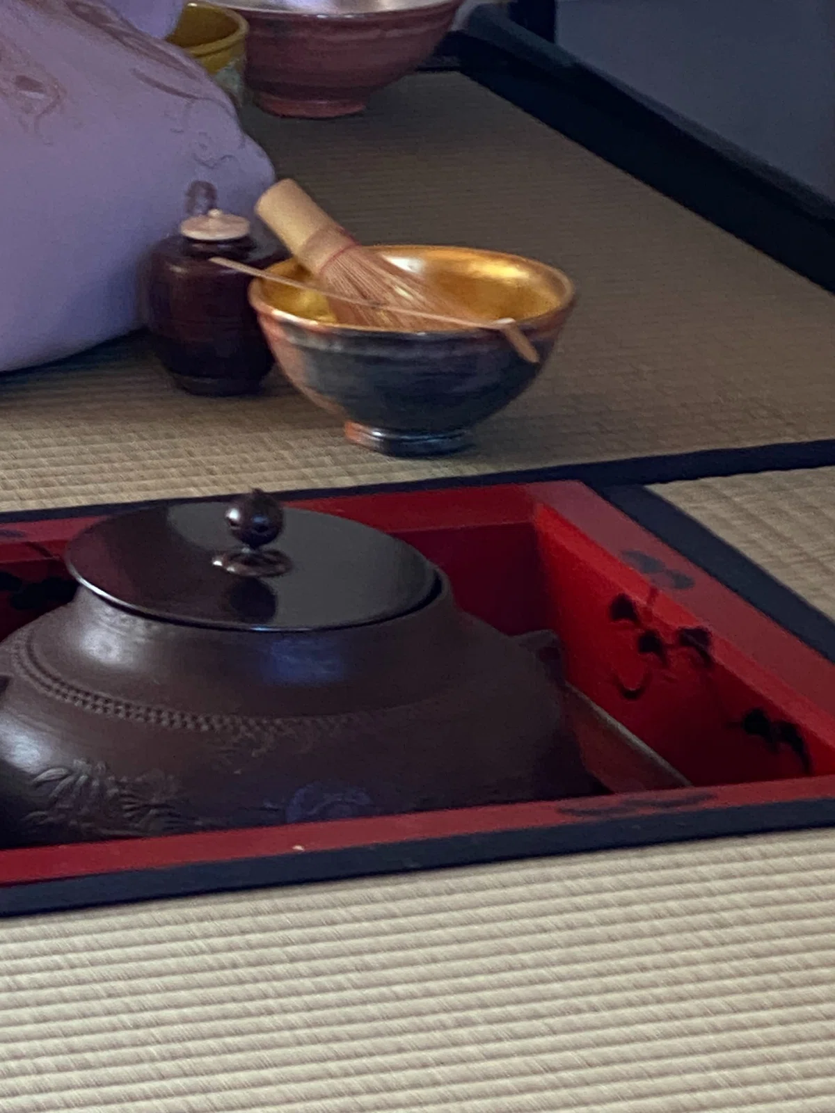 炉に懸けられた釜と、点前を待つ主茶碗と茶筅。初釜の濃茶点前が始まる茶碗は内側に金箔が貼られた赤楽の蓬莱茶碗。初釜の席で使われる。