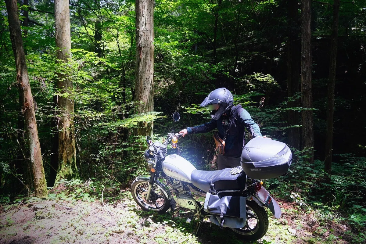 林道に佇むライダーとバイク