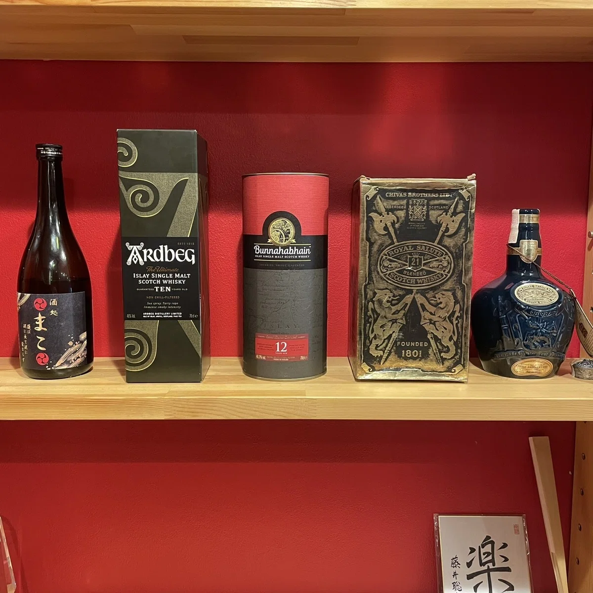 赤い壁の棚に並ぶお酒のボトル