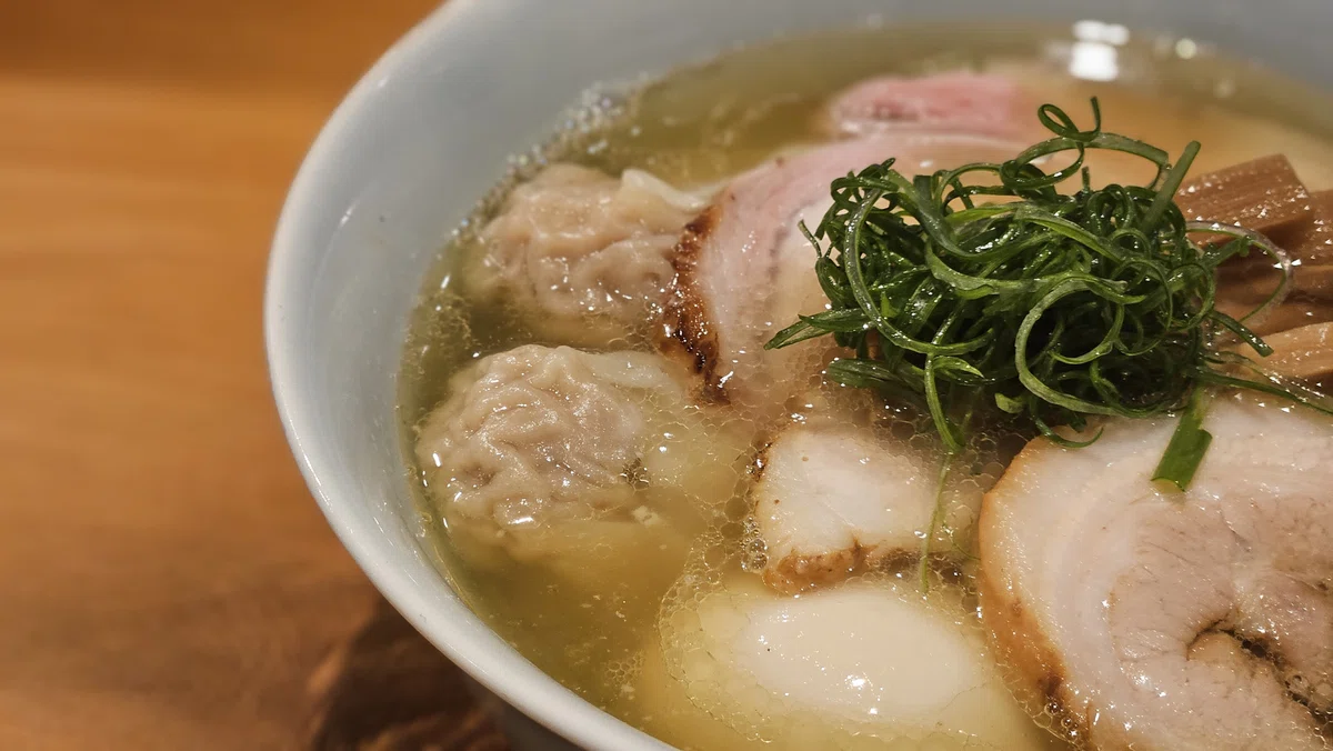 厚切りチャーシュー、わんたん、味玉が並ぶ特製塩そばのアップ写真。