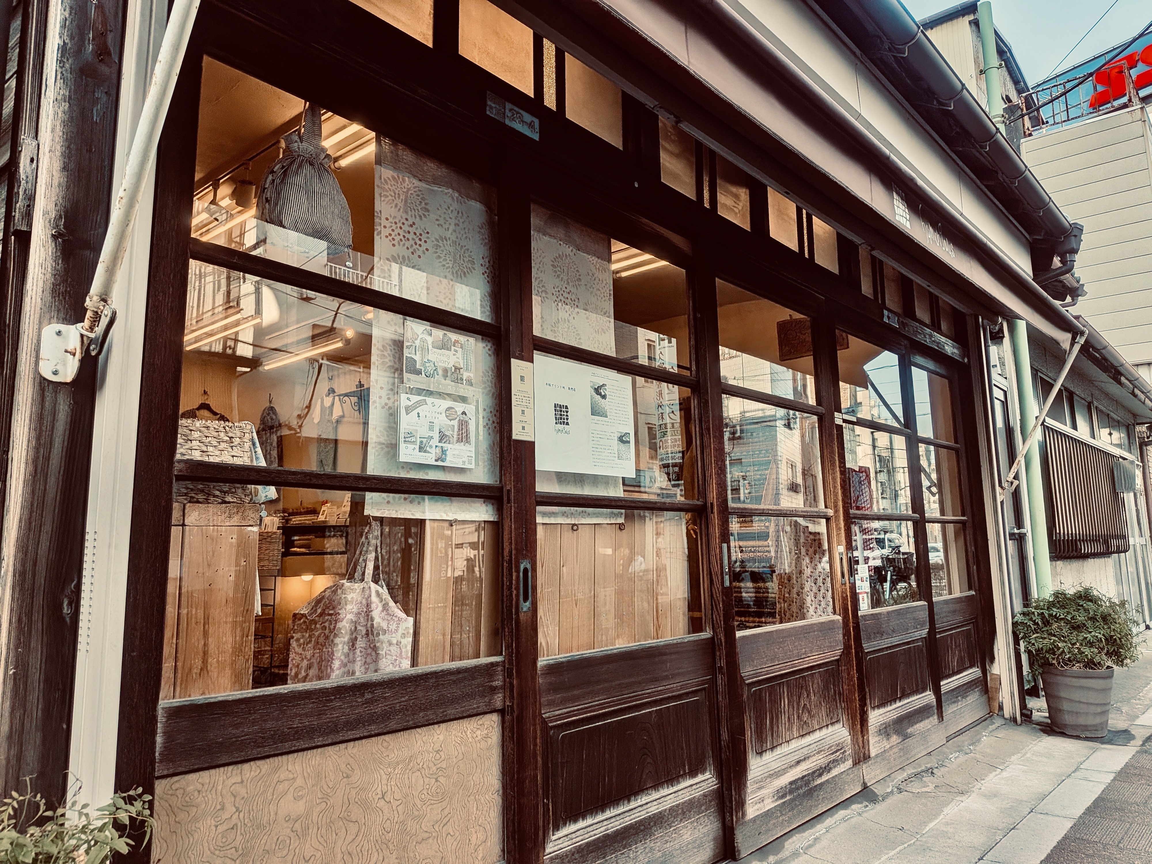 お店の入り口。昔ながらの木戸にガラスがはめこまれた引き戸。店内は明るく現代風にリノベーションされている。