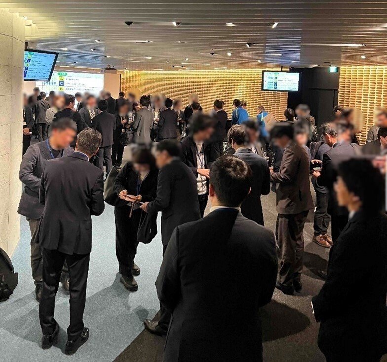 説明会終了後に行われた名刺交換会の様子。参加者が立ち並び、互いに向き合いながら名刺交換を行っている。