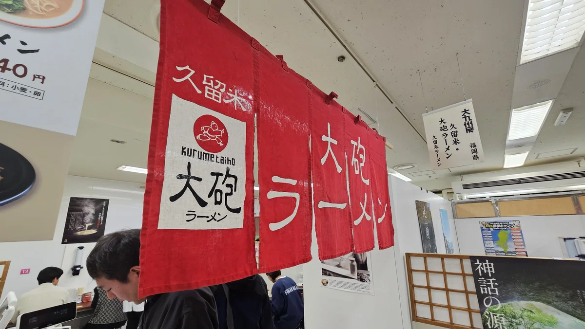大九州展に出店している久留米ラーメンの名店「大砲ラーメン」の赤い暖簾。現地の臨場感ある写真。note執筆中。