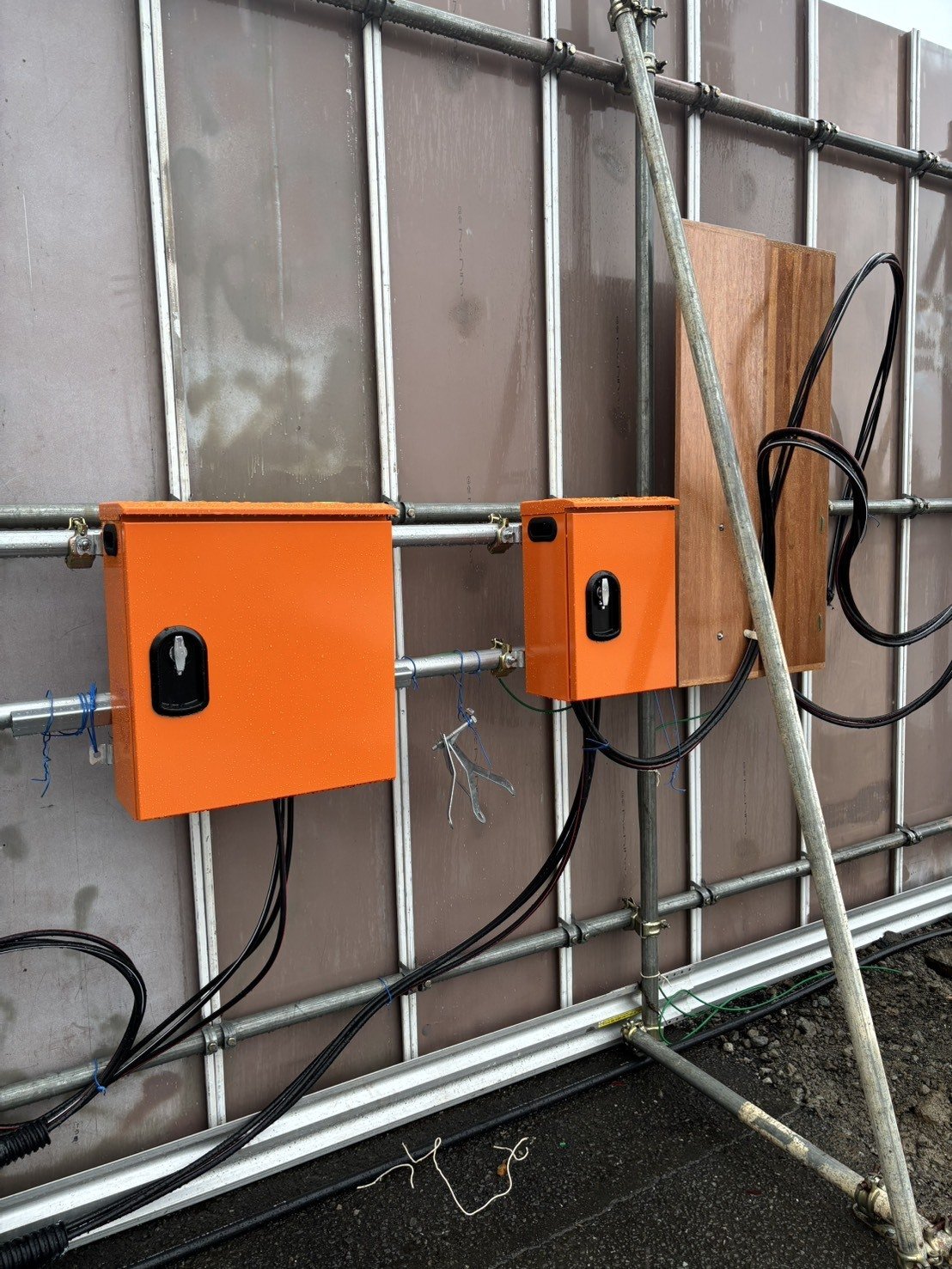 引込開閉器盤2台と計器板を仮囲いに取り付け