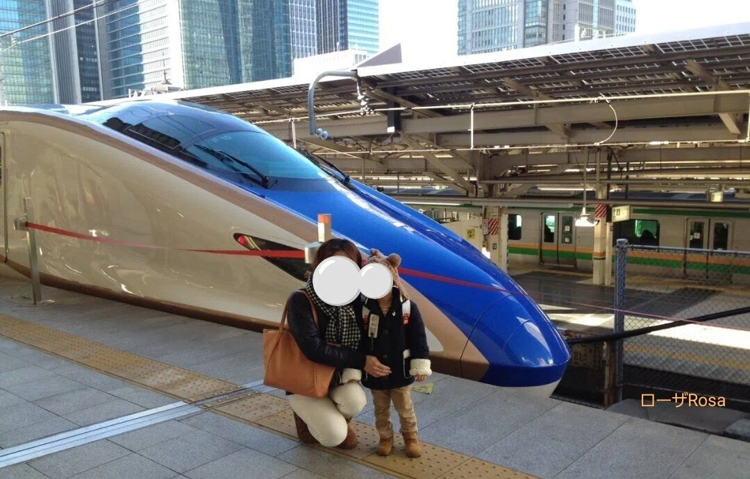 北陸新幹線の前で記念撮影している母子の画像