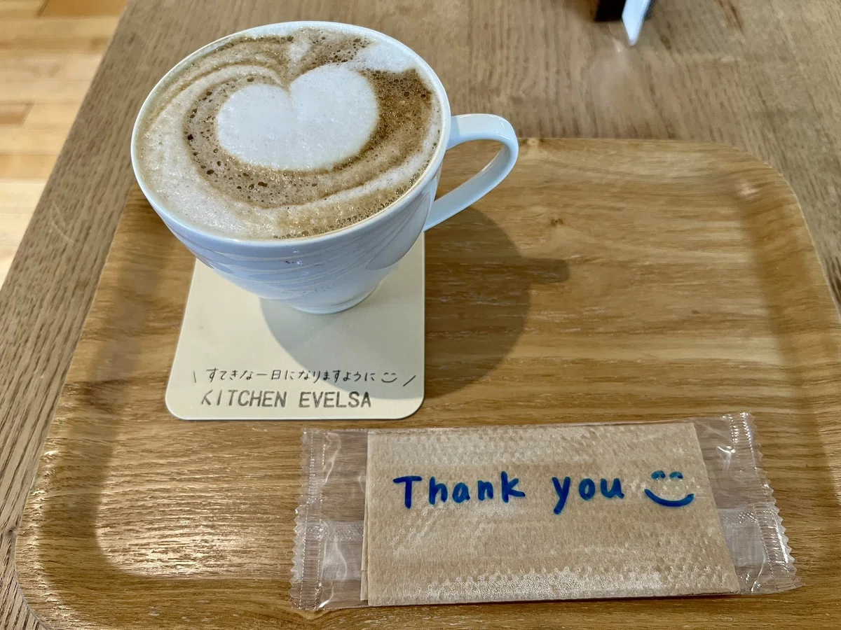 TOMAR １F KITCHEN EVELSAのほうじ茶ラテ（ホット）個包装のウェットティッシュのパッケージに、手書きでThank you :）のメッセージが書かれている