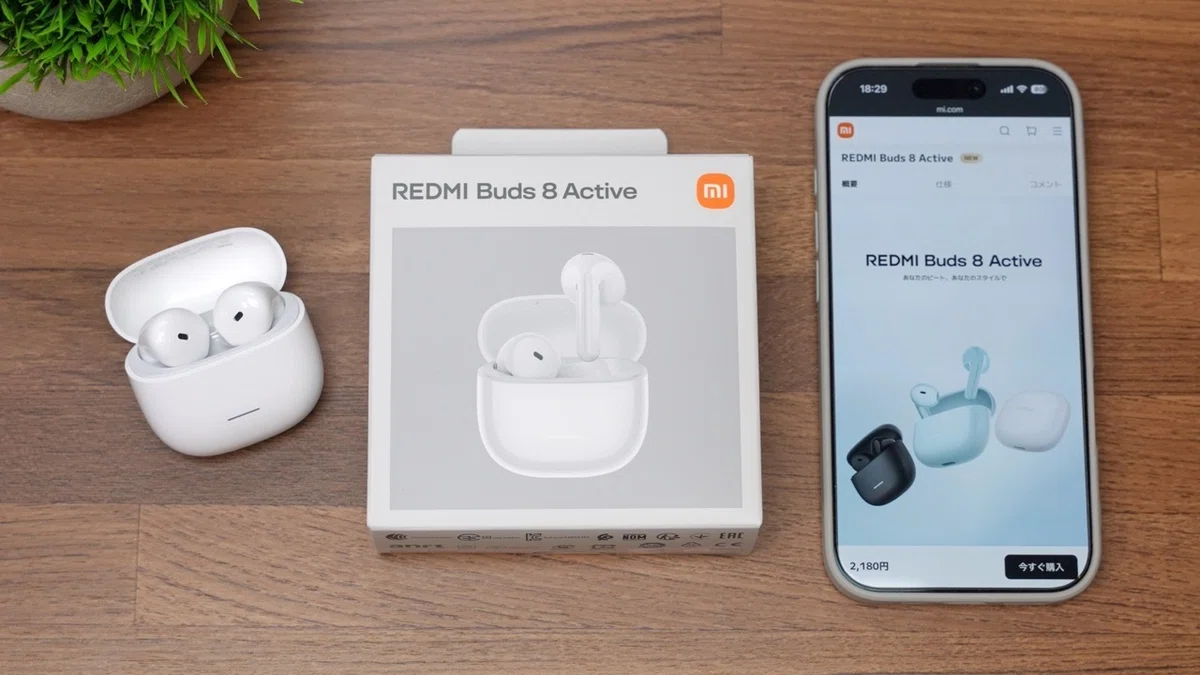 デスク上に置かれたホワイトカラーのREDMI Buds 8 Active本体とケース