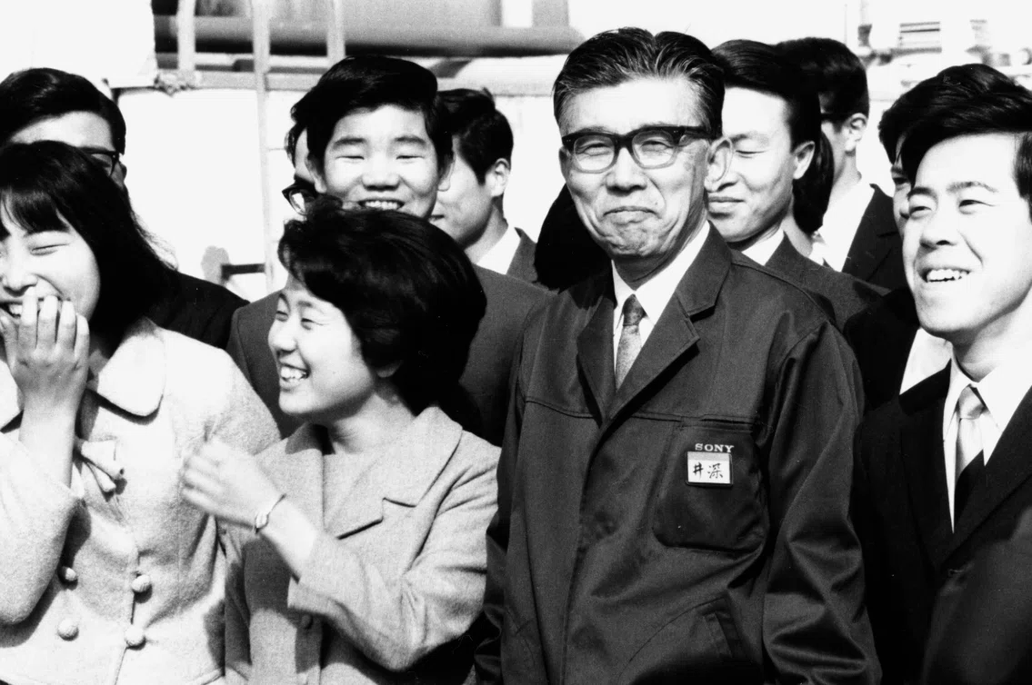 1969年／創立23年　入社式で新入社員に囲まれて笑顔の井深さん（61歳、右から2人目）