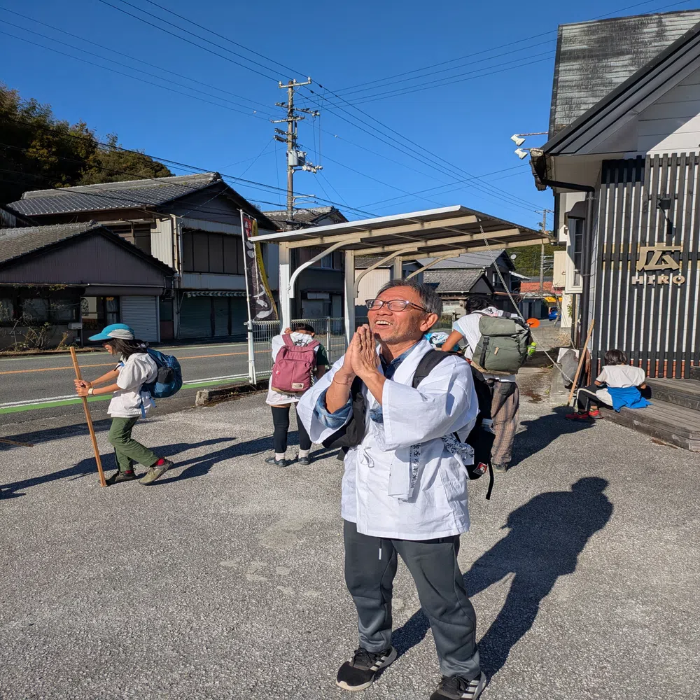 青空の下で合掌するお遍路さん