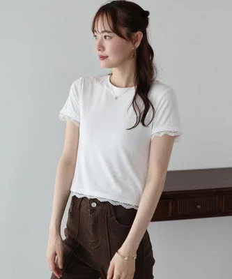 白の袖レースカットソーを濃いパンツに合わせた、40代向けの大人カジュアルコーデ。Tシャツ感覚で着られ、袖口と裾のレースがさりげなく華やかさを添えている