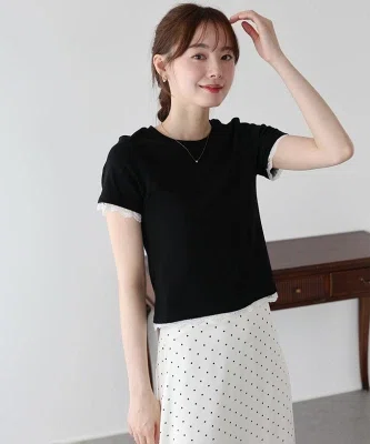 黒の袖レースカットソーを白のスカートに合わせた、40代向けの大人カジュアルコーデ。Tシャツ感覚で着られ、袖口と裾のレースがさりげなく華やかさを添えている
