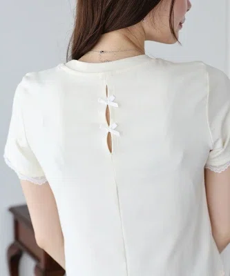 白の袖レースカットソーを濃いパンツに合わせた、40代向けの大人カジュアルコーデ。Tシャツ感覚で着られ、袖口と裾のレースがさりげなく華やかさを添えている