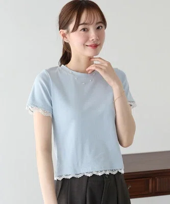 青の袖レースカットソーを濃いパンツに合わせた、40代向けの大人カジュアルコーデ。Tシャツ感覚で着られ、袖口と裾のレースがさりげなく華やかさを添えている