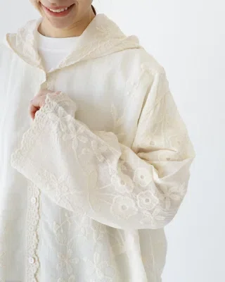 花刺繍の入ったホワイト系の薄手フーディーシャツを使った普段着コーデ。日除けや冷房対策に使いやすく、ゆったりしたシルエットで体のラインを拾いにくい春夏向けの軽い羽織り