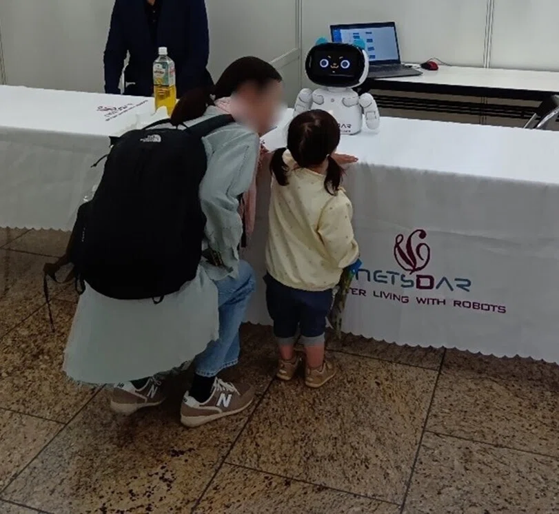 AIコミュニケーションロボットとお子様が会話している様子