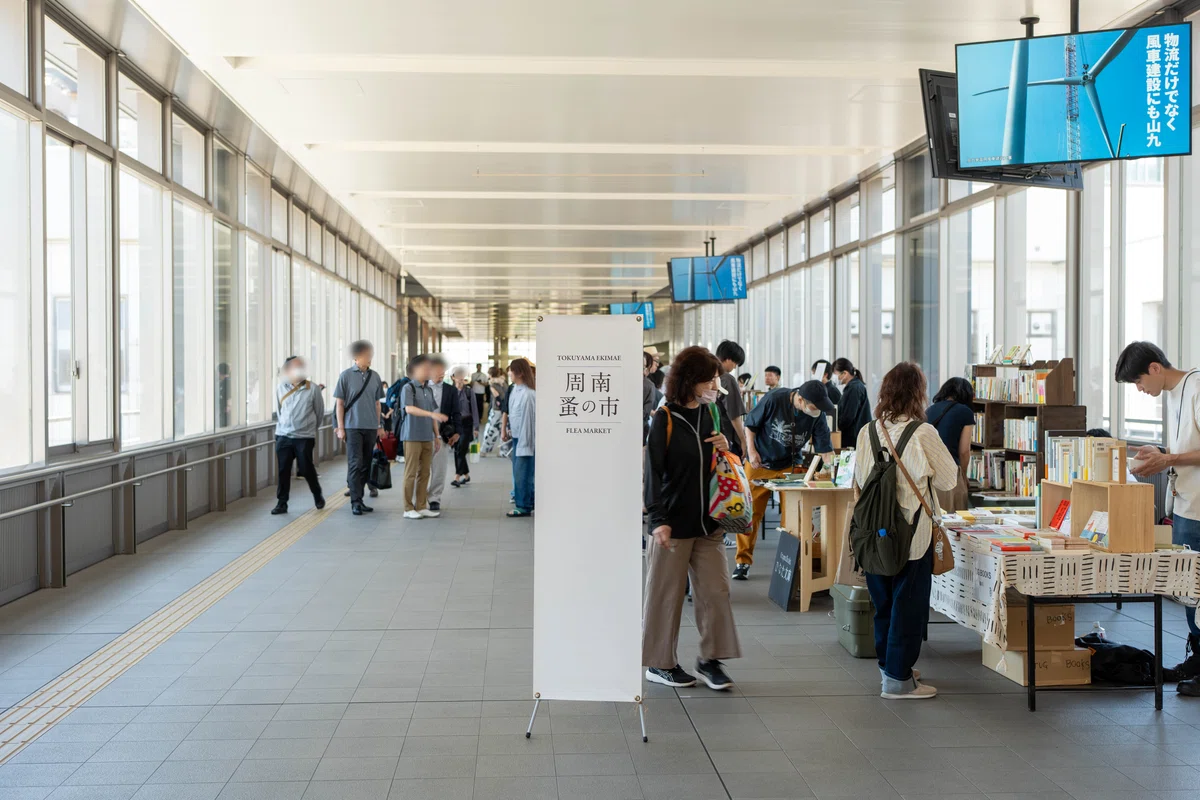 通路に並ぶブースと中央に「周南 蚤の市」の看板
