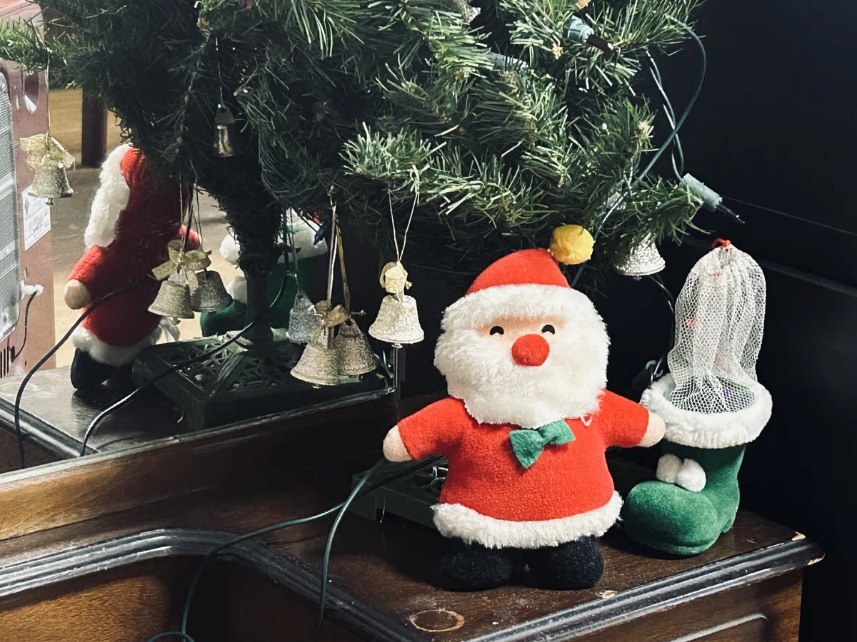 クリスマスツリーの前にサンタの人形がいる