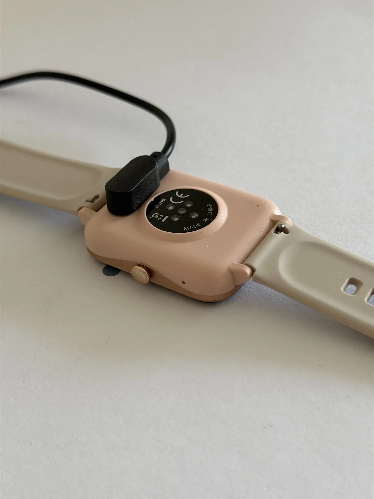 GRV FC1スマートウォッチを充電している状態。背面に磁石付きのコネクタを付けている。