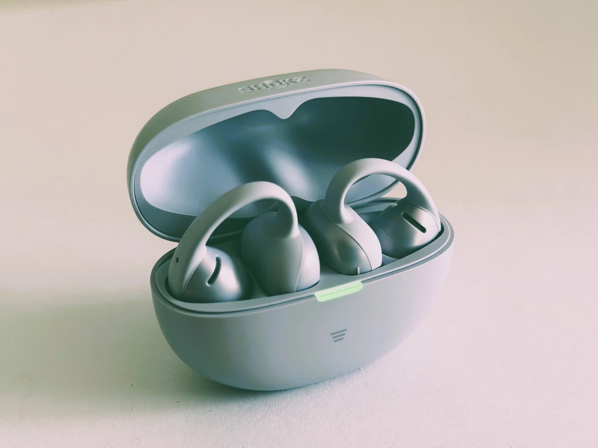 Shokz OpenDots Air デイブレイクパープル。耳に挟んで使うイヤーカフ型イヤホンのケースを開けた写真。
