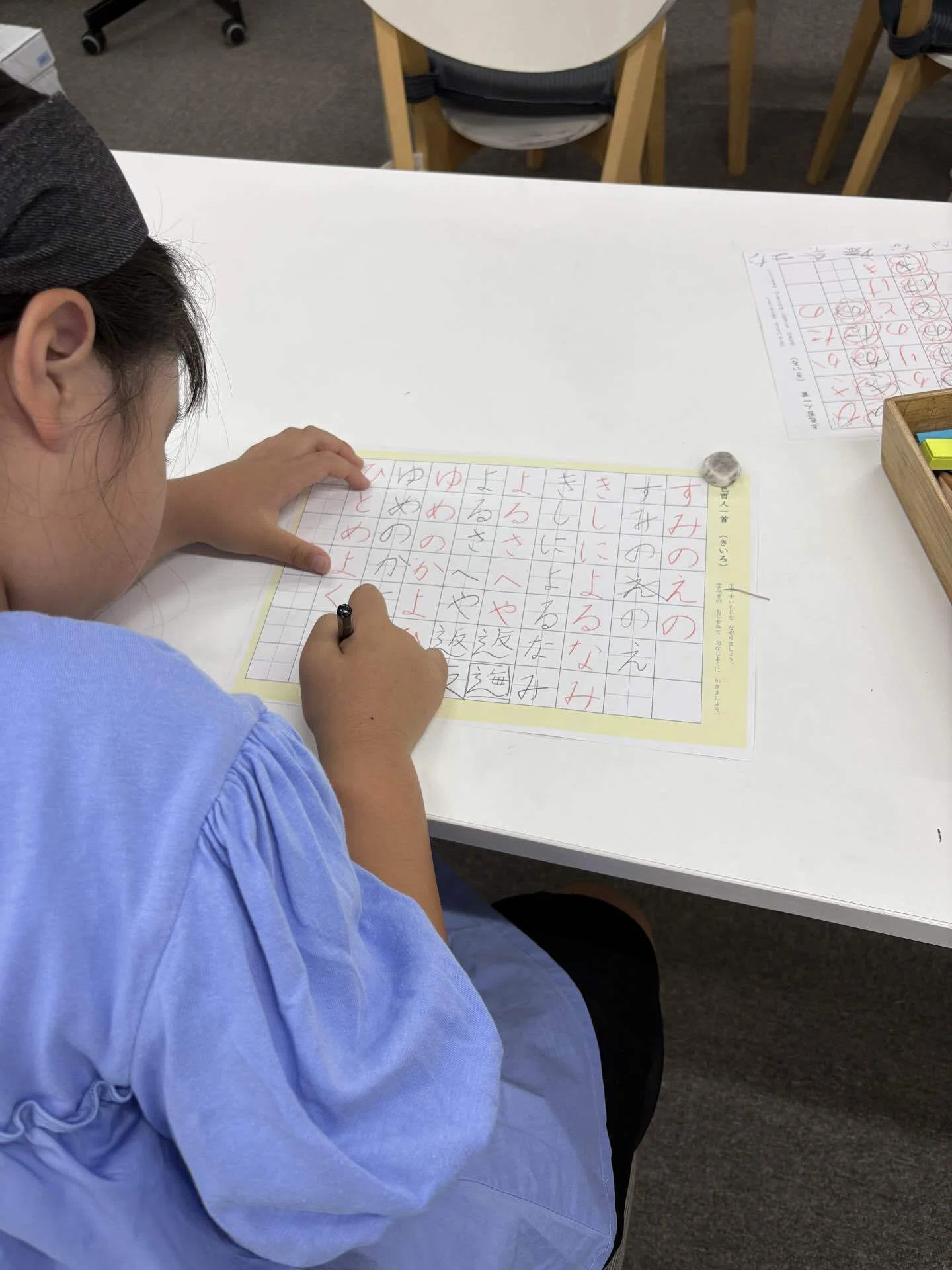百人一首の歌を原稿用紙へ書く子ども