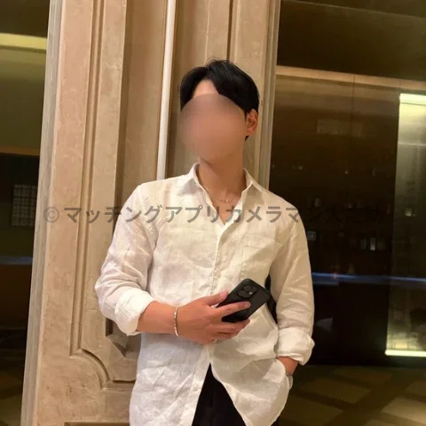 男性が日比谷ミッドタウンの飲食店の前で立っている姿を写したマッチングアプリ用のプロフィール写真