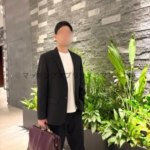 ブルーフロント芝浦のエントランスに立つ男性の姿を写したマッチングアプリ用のプロフィール写真