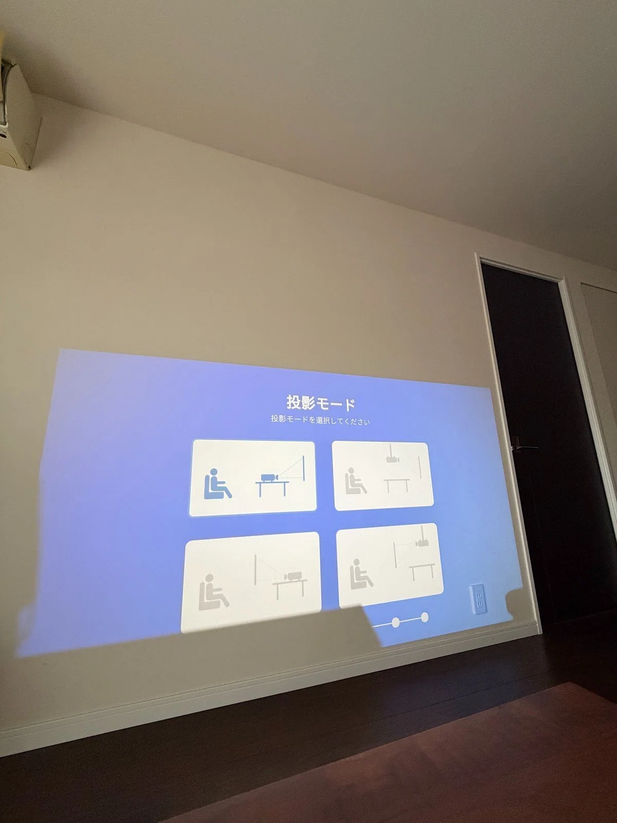 ナイトテーブルの上から投影したところ、画面が壁のやや低い位置に映っている様子。