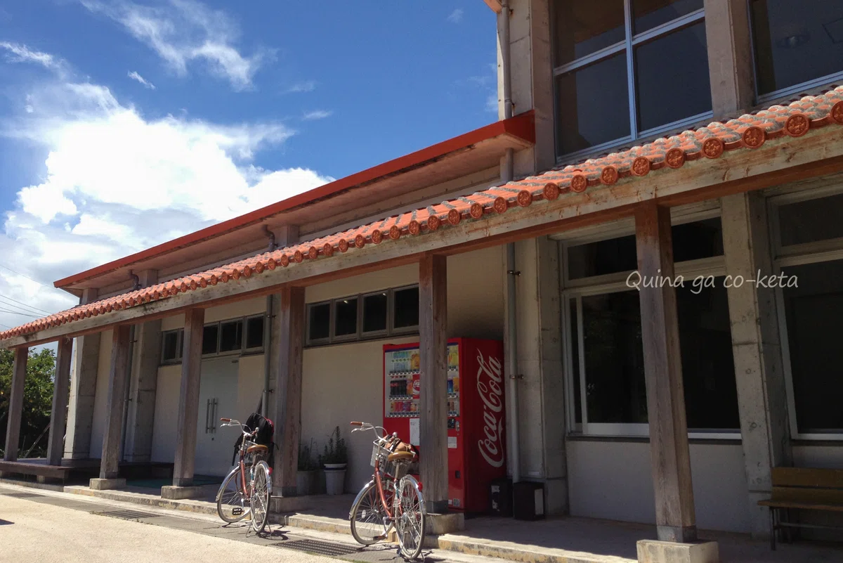 赤瓦の公民館の前にレンタサイクルが2台とまっている