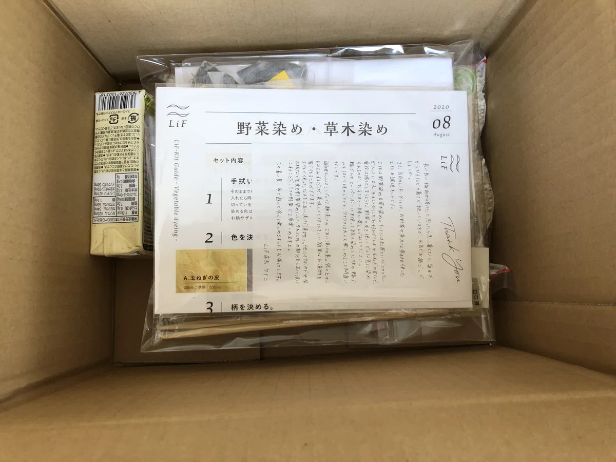 LiFの8月キット。段ボールに、野菜染め・草木染めのガイド、材料、手書きのサンクスレターが入っている