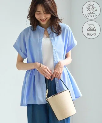 腰まわりにゆとりのあるブルーのペプラムシャツ。体の線を拾いにくいシルエットが分かる一枚
