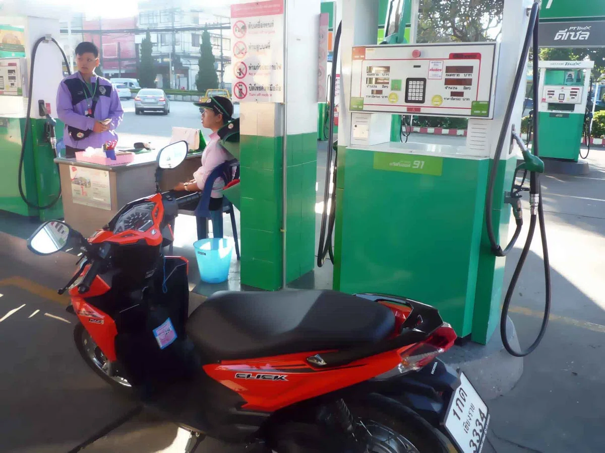 ガソリンスタンドの給油機前に停められた赤いホンダのスクーター