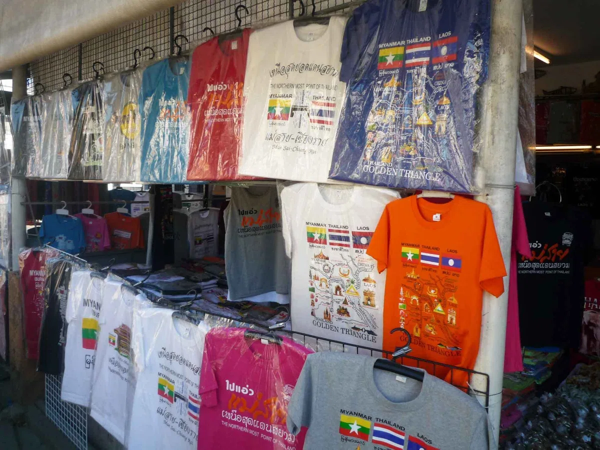 タイ、ミャンマー、ラオスの国旗や「GOLDEN TRIANGLE」の文字がプリントされたTシャツが店先に並んでいる