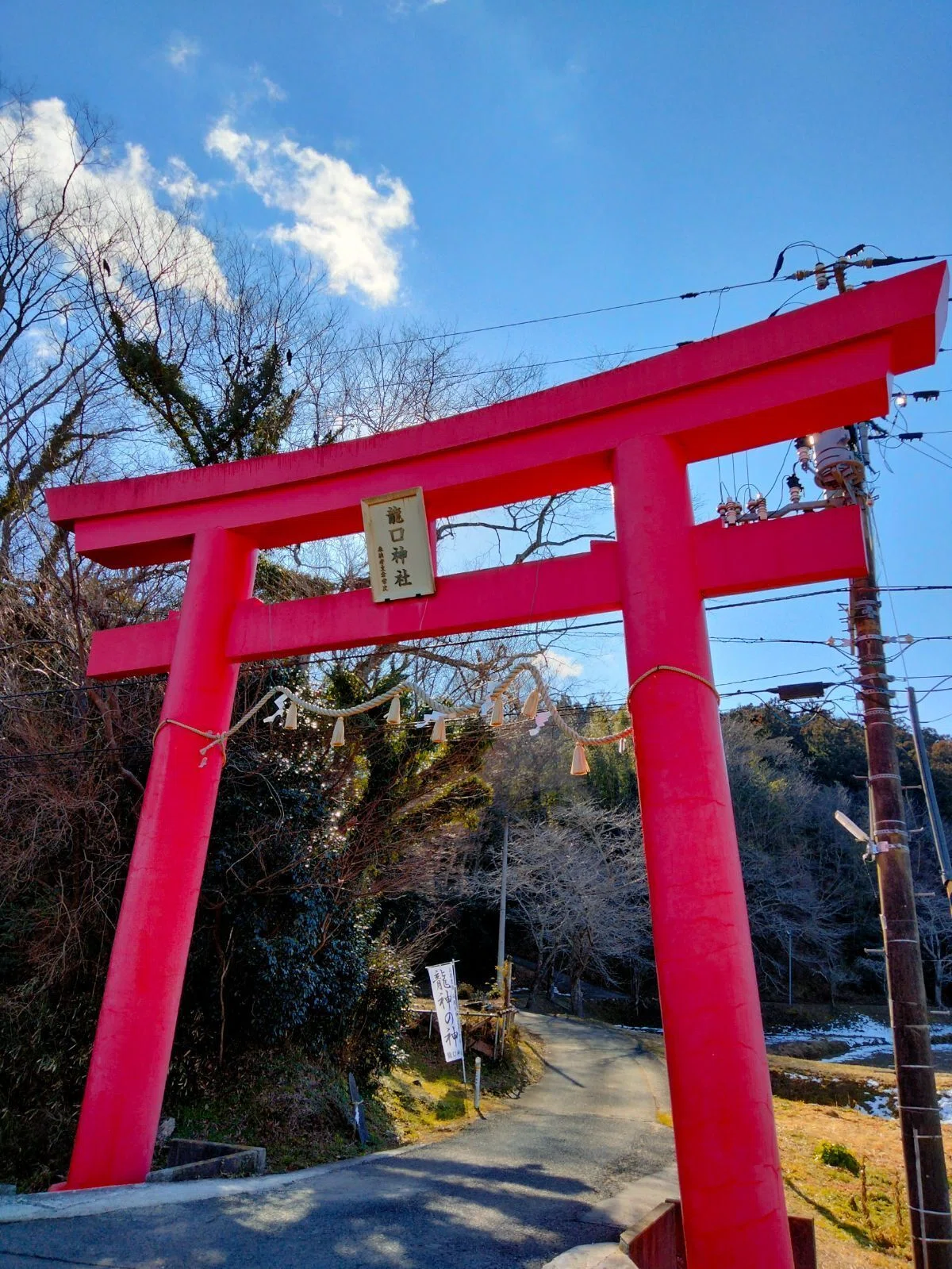 青空の下に立つ龍口神社の朱色の一ノ鳥居