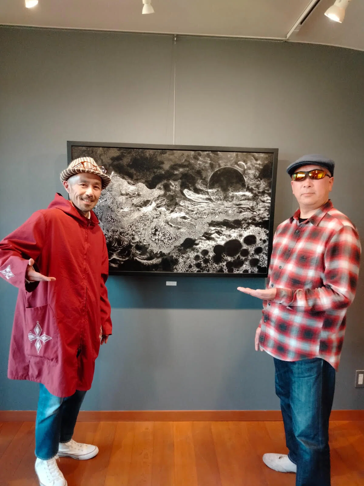龍の墨絵作品の前に立つ墨絵師の小山康博氏と白眉最良さん
