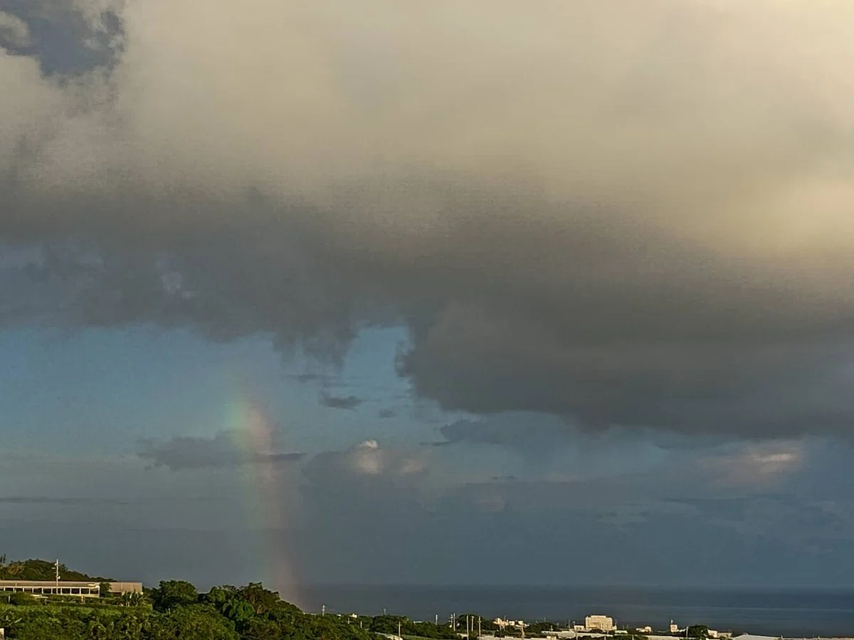 海から立ち昇る虹、上は雲に覆われている